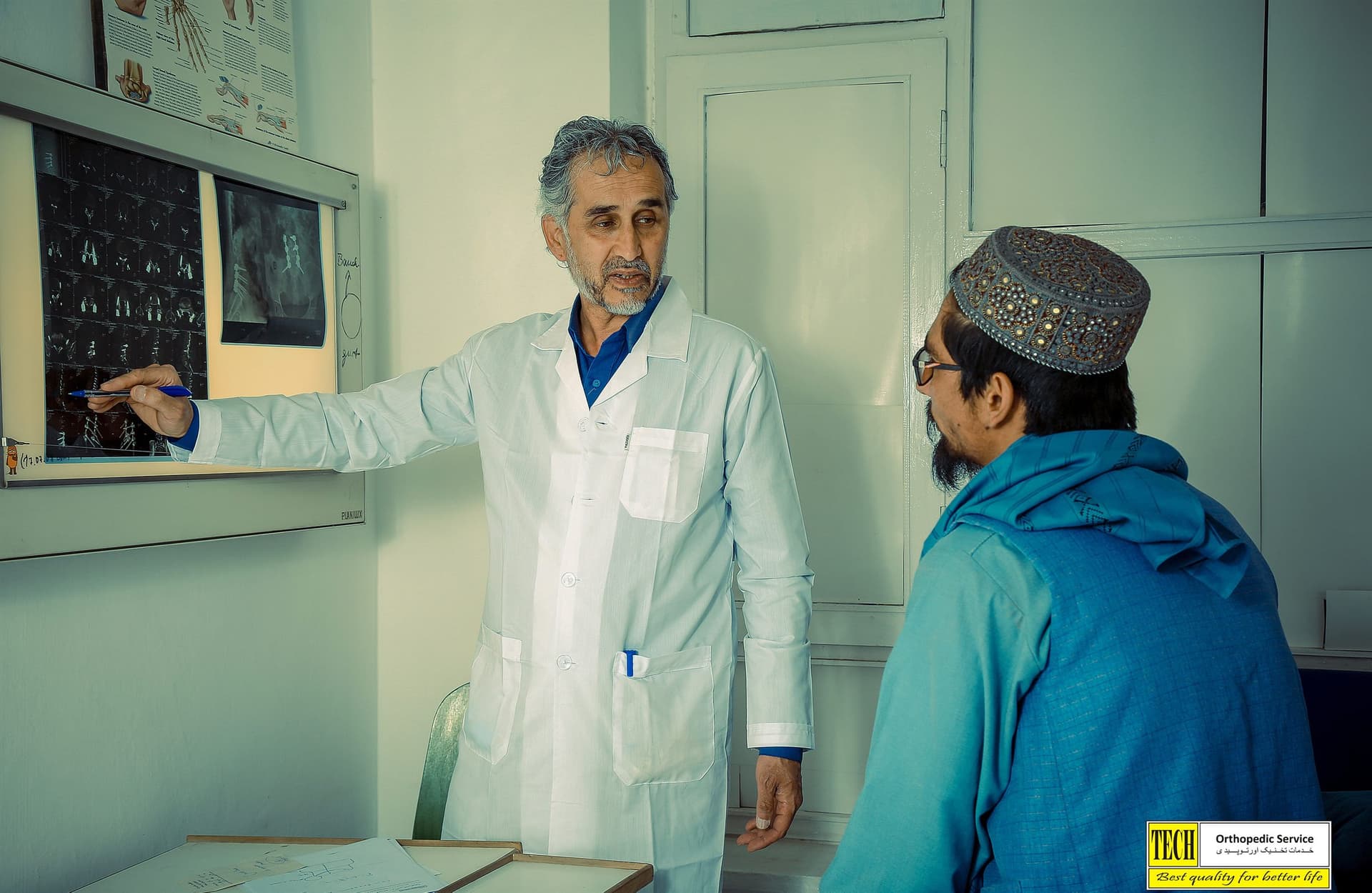 A Tech Orthopedic clinician reviewing X-rays with a patient in Kabul